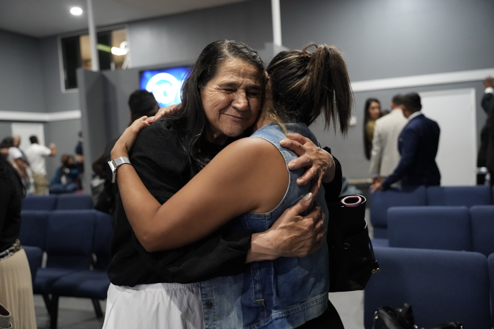 Dos hermanas se abrazan al terminar el servicio en Iglesia Cristo Vive, West Palm Beach.